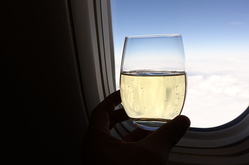 飛行機でシャンパンを飲む